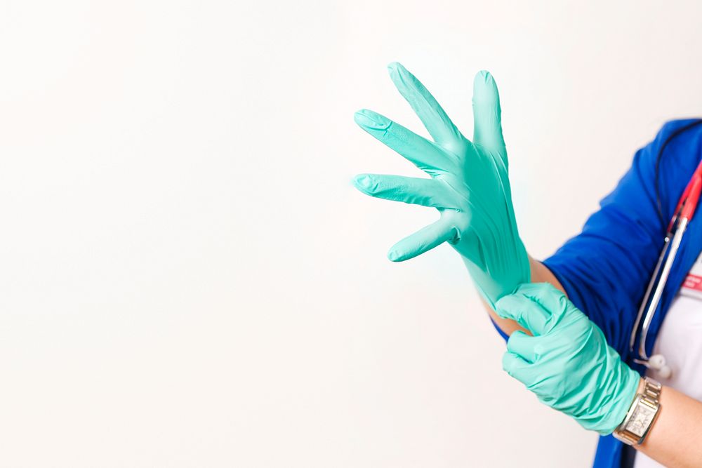 Nurse wearing green latex gloves to protect herself. Original image sourced from US Government department: Public Health…