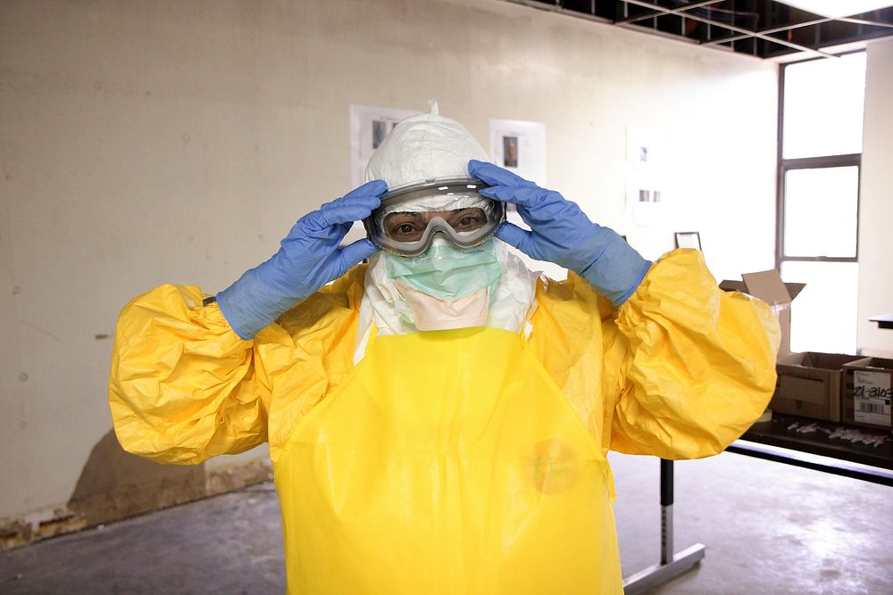 A healthcare worker donning a pair of protective goggles and protective equipment. Original image sourced from US Government…