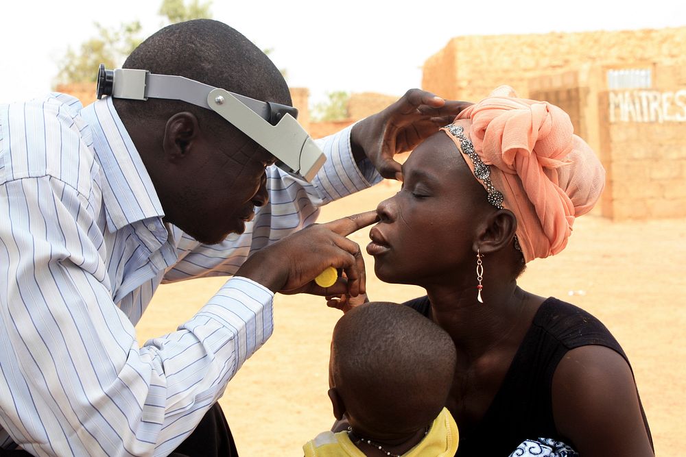 A diagnostic technician performing an eye exam. Original image sourced from US Government department: Public Health Image…