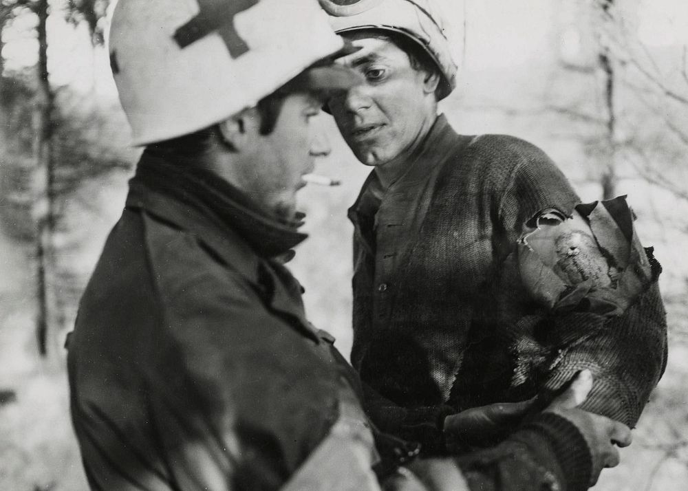 Medic giving first aid to soldier in Belgium, World War II. Original image from National Museum of Health and Medicine.…
