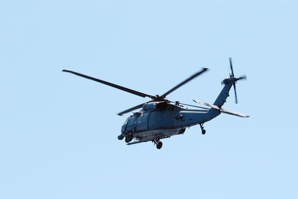 An HH-60G helicopter flies overhead of a rescue boat during a training exercise, known as Mode VIII. Original from NASA.…