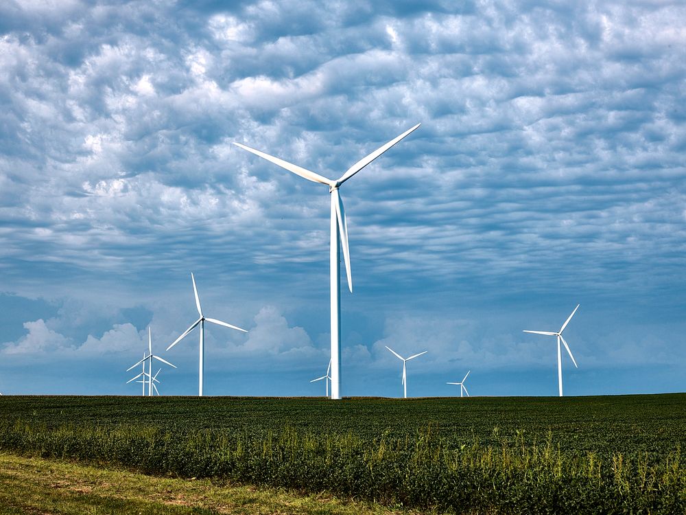 Wind farms filled with giant wind turbines have become a familiar site on actual American prairie farms, Iowa. Original…