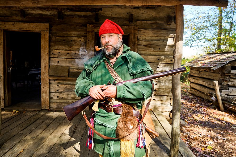 Mountain Man character in front of cabins at the Hickory Ridge Living History Museum in Boone, North Carolina. Original…
