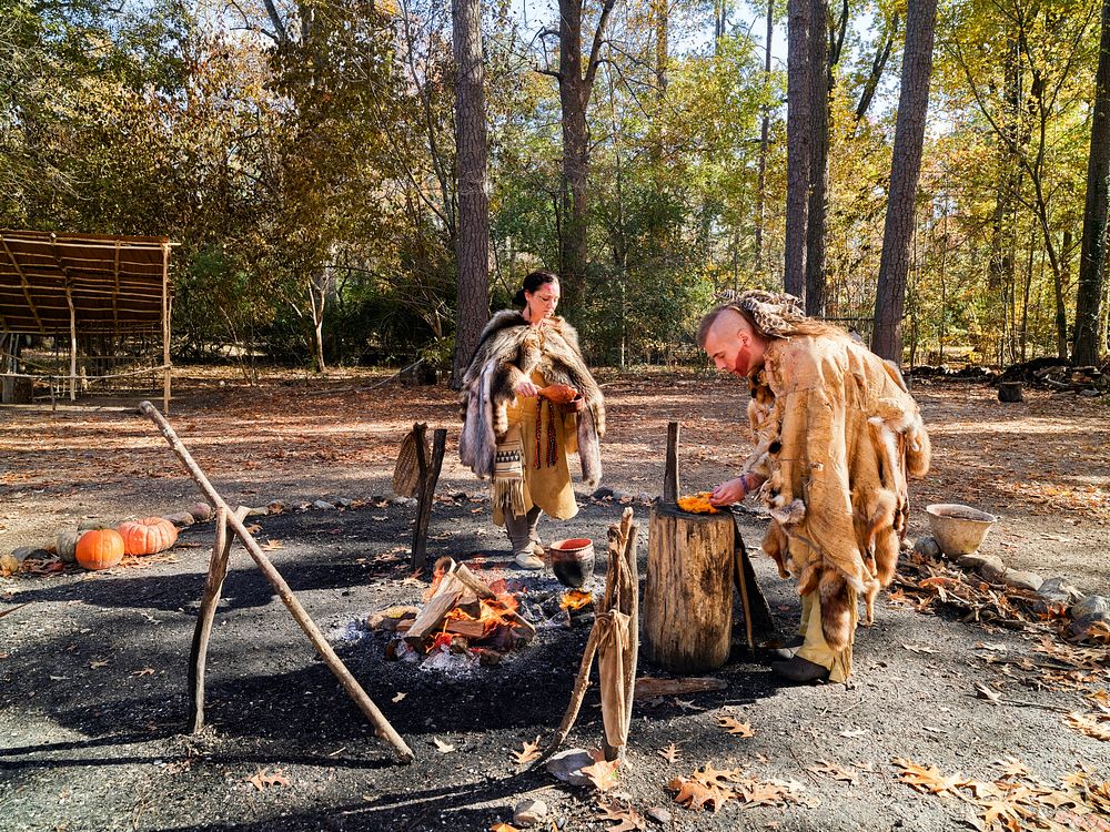 Historic interpreters prepare a meal in the re-created Powhatan Indian Village at the Jamestown Settlement living-history…