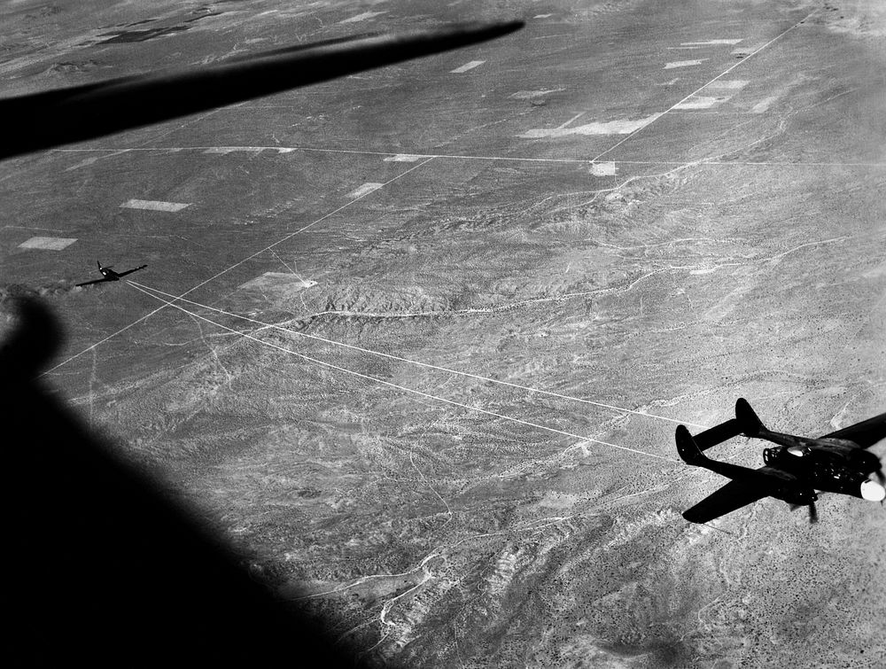 NACA photographer Northrop P-61A Black Widow towing P-51B to release altitude of 28,000 ft over Muroc Dry Lake, California…