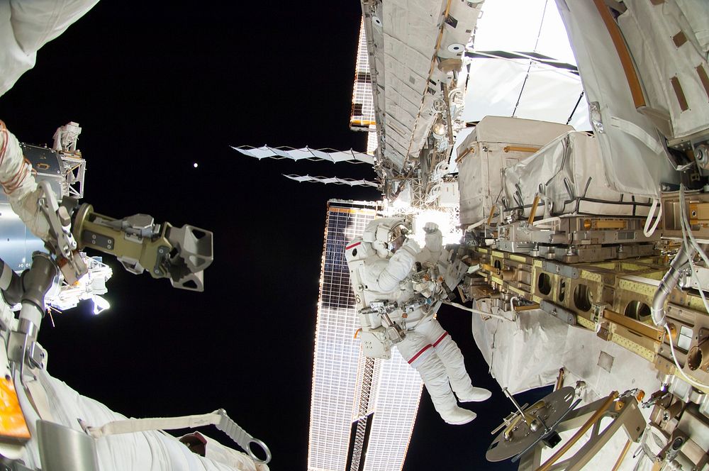 Astronauts working outside the space station's Quest airlock in Oct 7, 2014. Original from NASA. Digitally enhanced by…