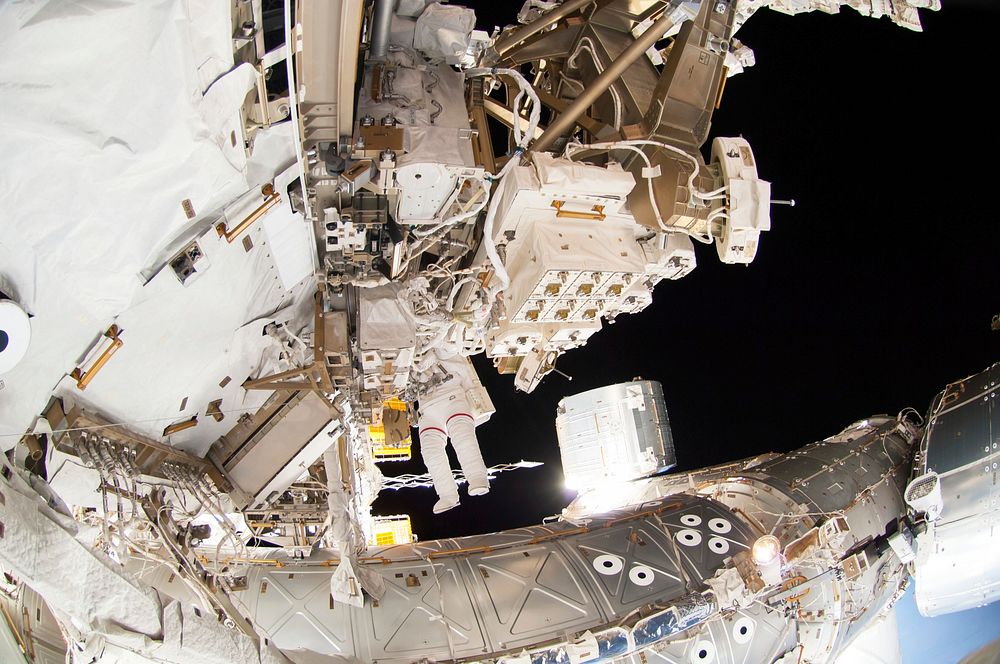 Astronauts working outside the space station's Quest airlock in Oct 7, 2014. Original from NASA . Digitally enhanced by…