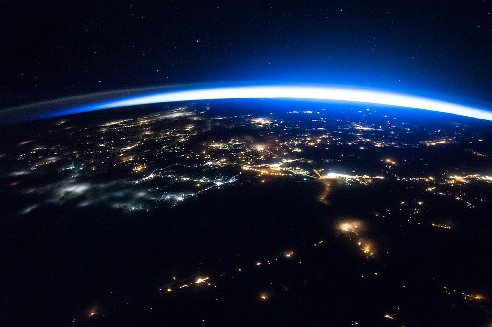 Night image of sparkling cities and a sliver of daylight framing the northern hemisphere. Original from NASA. Digitally…