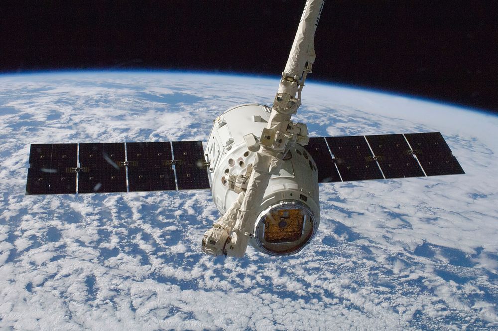 The SpaceX Dragon commercial cargo craft is grappled by the International Space Station&rsquo;s Canadarm2 robotic arm. Oct…