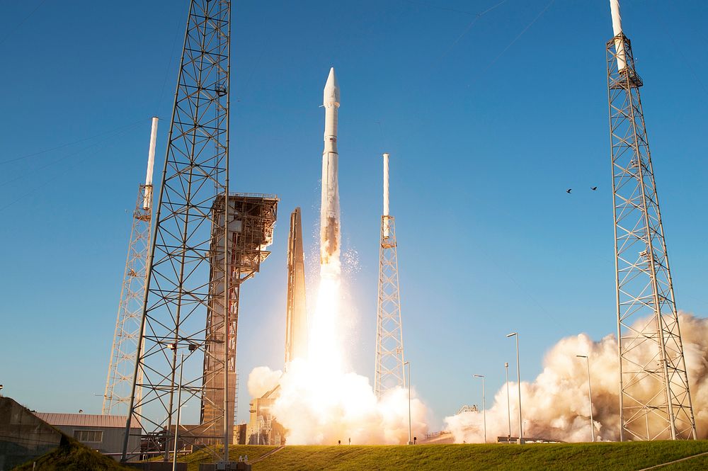 Rising from fire and smoke, NASA's Juno planetary probe, enclosed in its payload fairing, launches atop a United Launch…