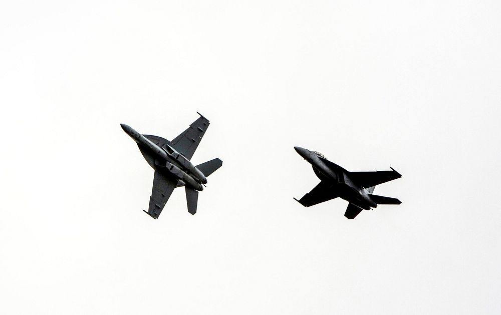 Two F/A-18 jets fly over the Shuttle Landing Facility at NASA's Kennedy Space Center in Florida. Original from NASA.…