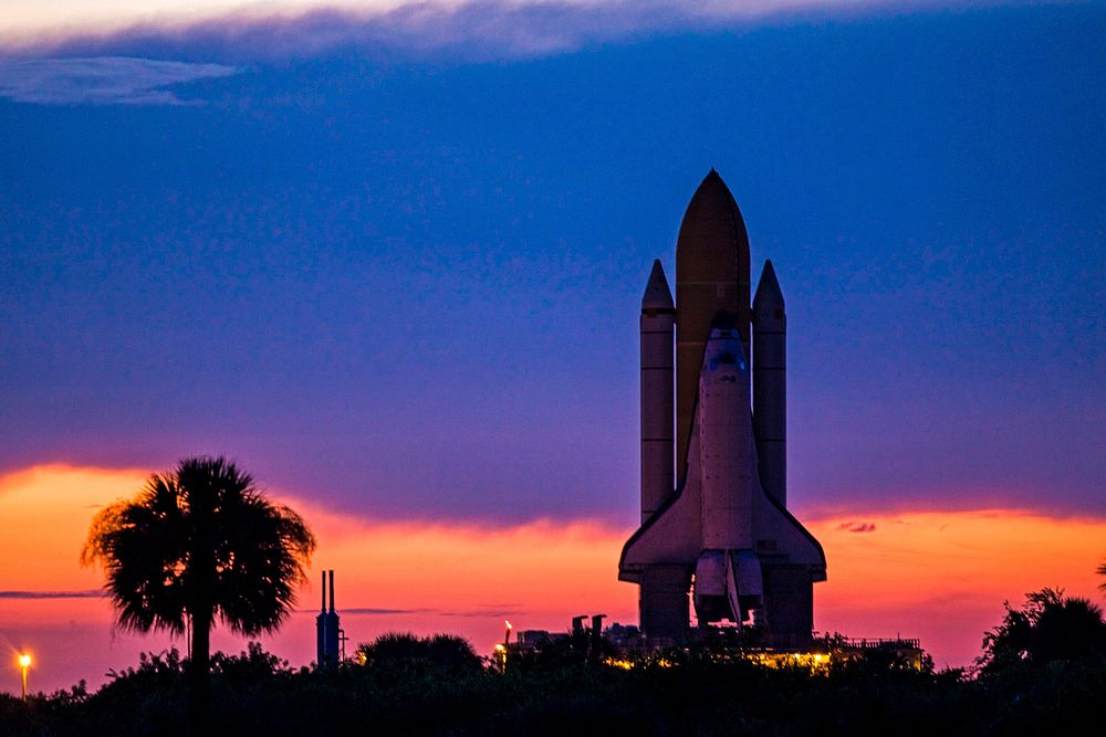 Space shuttle Discovery is silhouetted against the dawn sky as it rolls out to Launch Pad 39A at NASA's Kennedy Space Center…