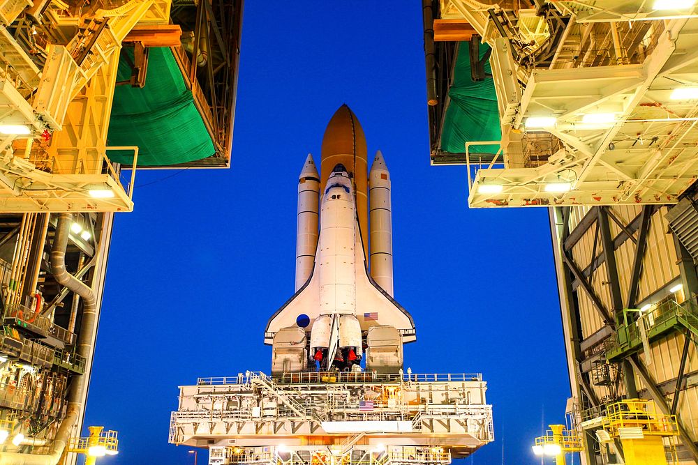 At NASA's Kennedy Space Center in Florida, space shuttle Discovery begins its nighttime trek, known as rollout, from the…