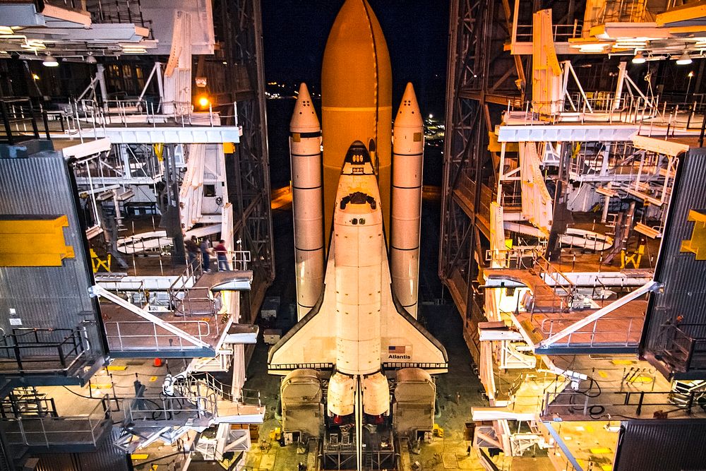 Space shuttle Atlantis, attached to its bright-orange external fuel tank and twin solid rocket boosters on Launch Pad 39A at…