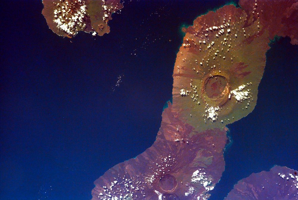 This image of the Galapagos Islands captures two large shield volcanoes on Isla Isabella. Original from NASA. Digitally…