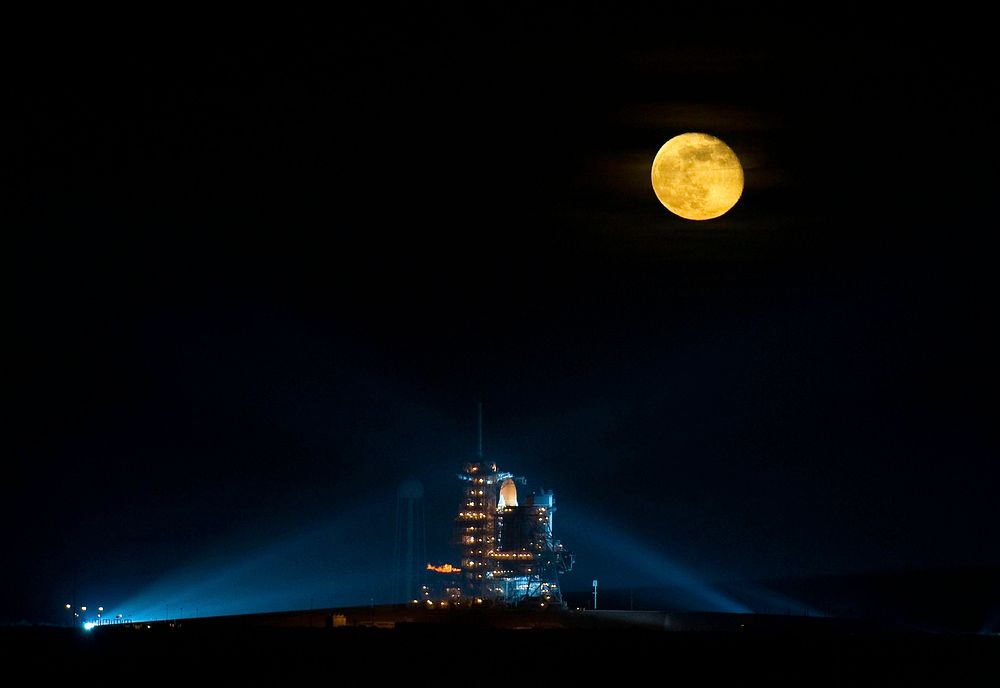 The moon is seen rising behind the Space Shuttle Endeavour on pad 39A. Original from NASA. Digitally enhanced by rawpixel.