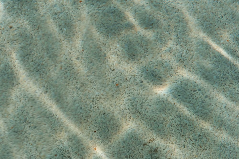 Abstract ripple water pattern in a swimming pool with sun reflection