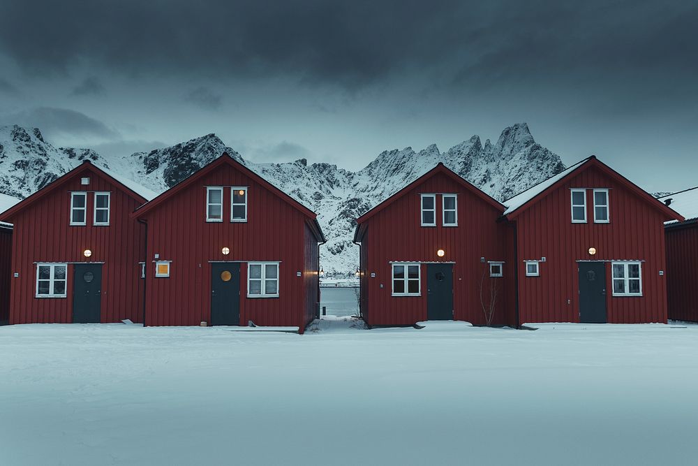 Row of red cabins on a snowy coast of Sakrisoy island, Norway