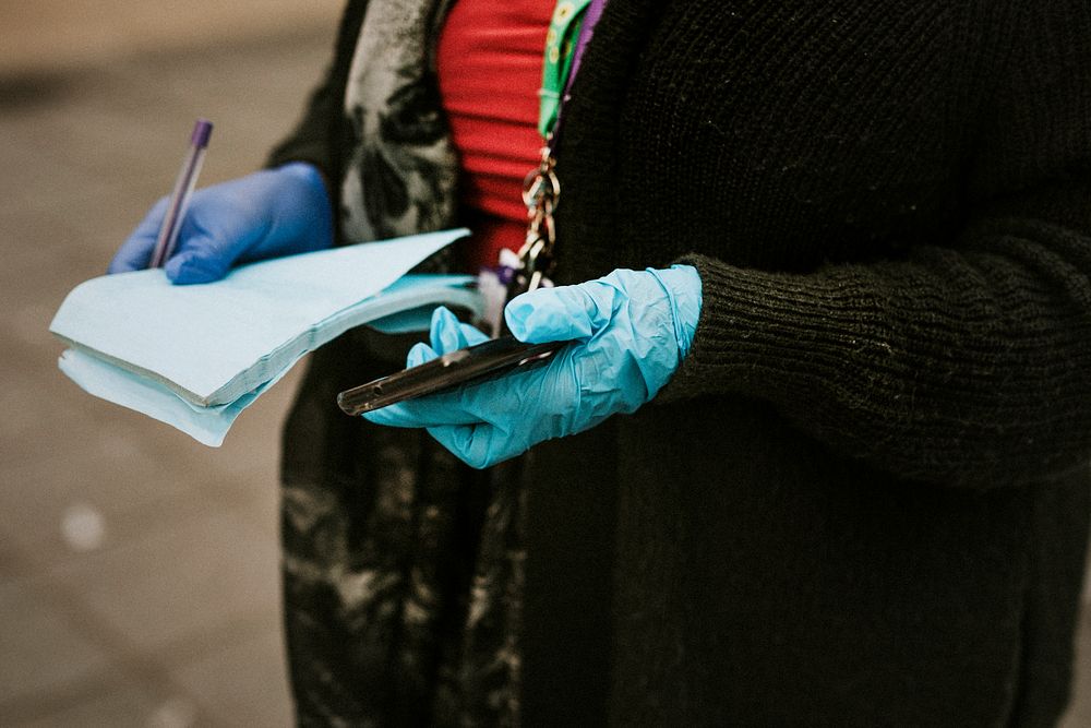 Woman wearing protective latex gloves and holding a phone. BRISTOL, UK, March 30, 2020