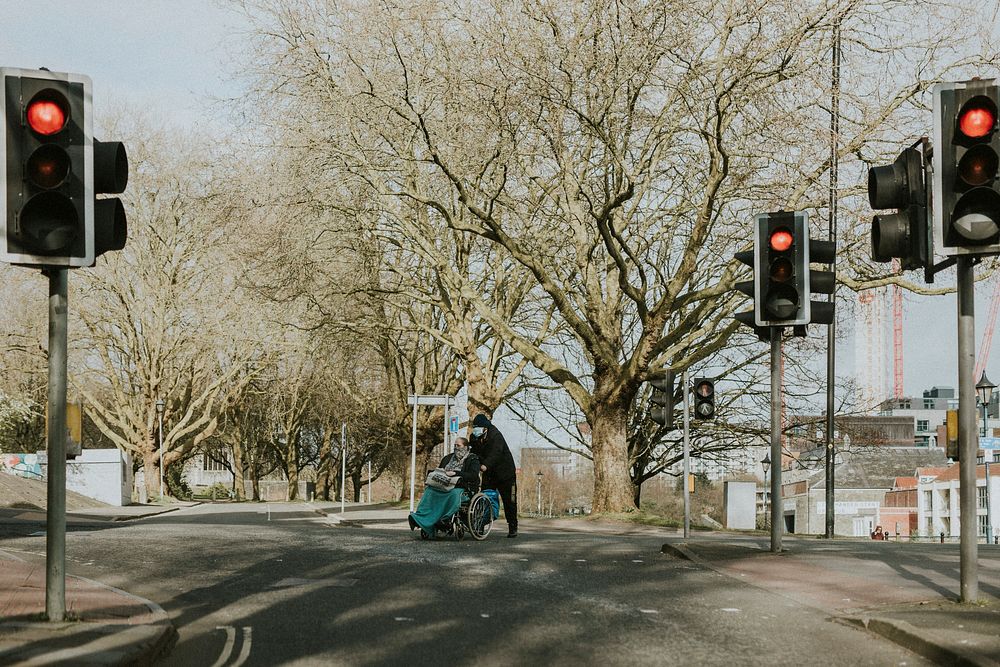 Handicapped woman and son crossing a street during coronavirus outbreak. BRISTOL, UK, March 30, 2020