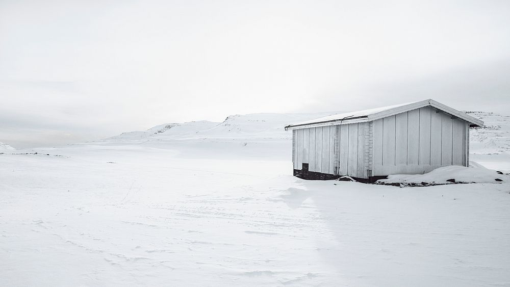 White abandoned wooden cabin in the snowy countryside of Greenland