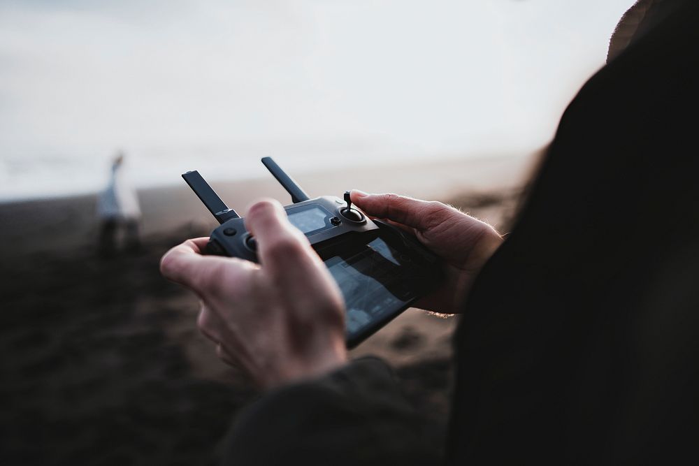 Man controlling a drone by a remote control