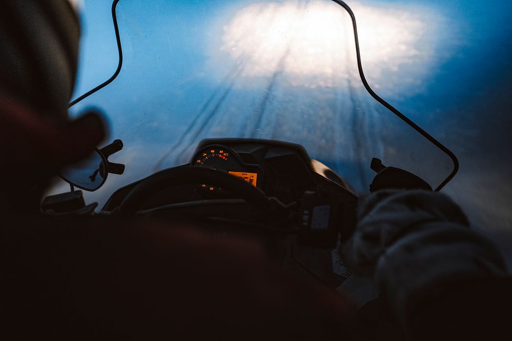 Man riding a snowmobile in the evening