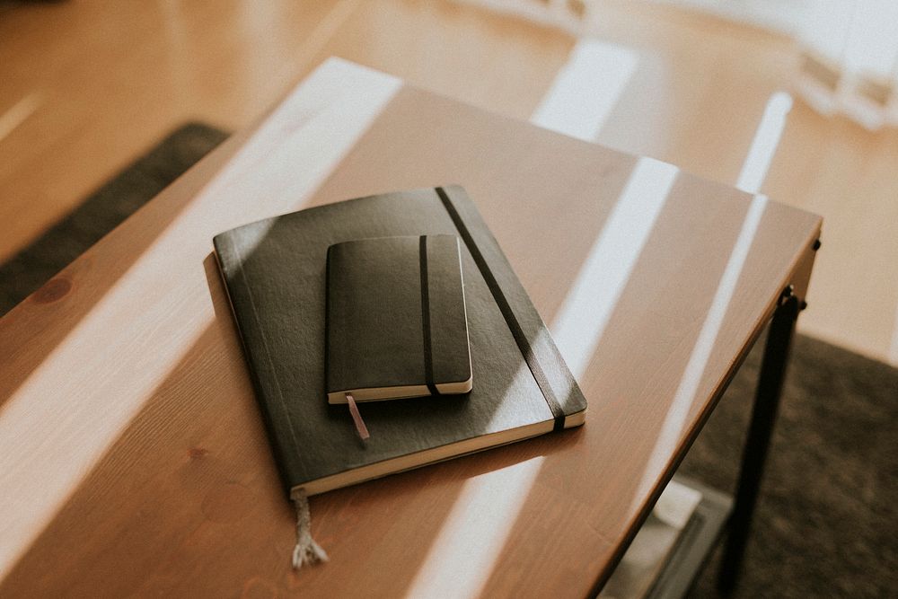 Brown notebooks on a wooden desk