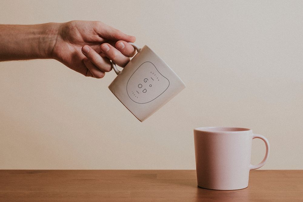Hand holding a ceramic coffee cup mockup