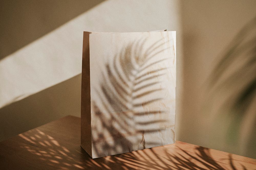 Natural paper bag with palm leaves shadow