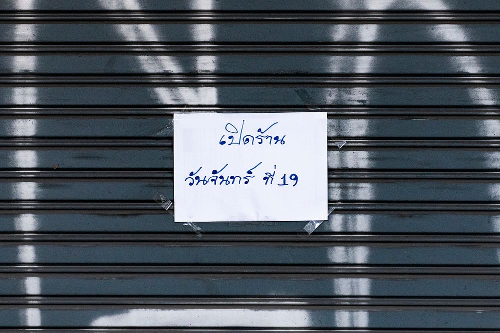 Paper shop sign on rolling door in Bangkok