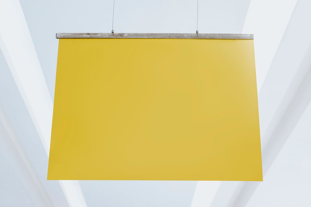 Yellow poster sign mockup psd hanging from a ceiling