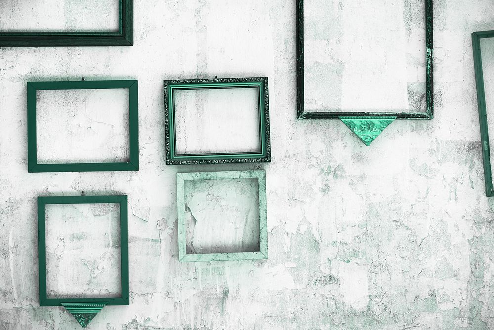 Various green frames on a peeled plaster wall
