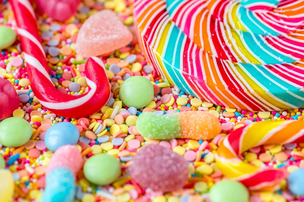 Close up of candycane and lollipop on a colorful sweets background