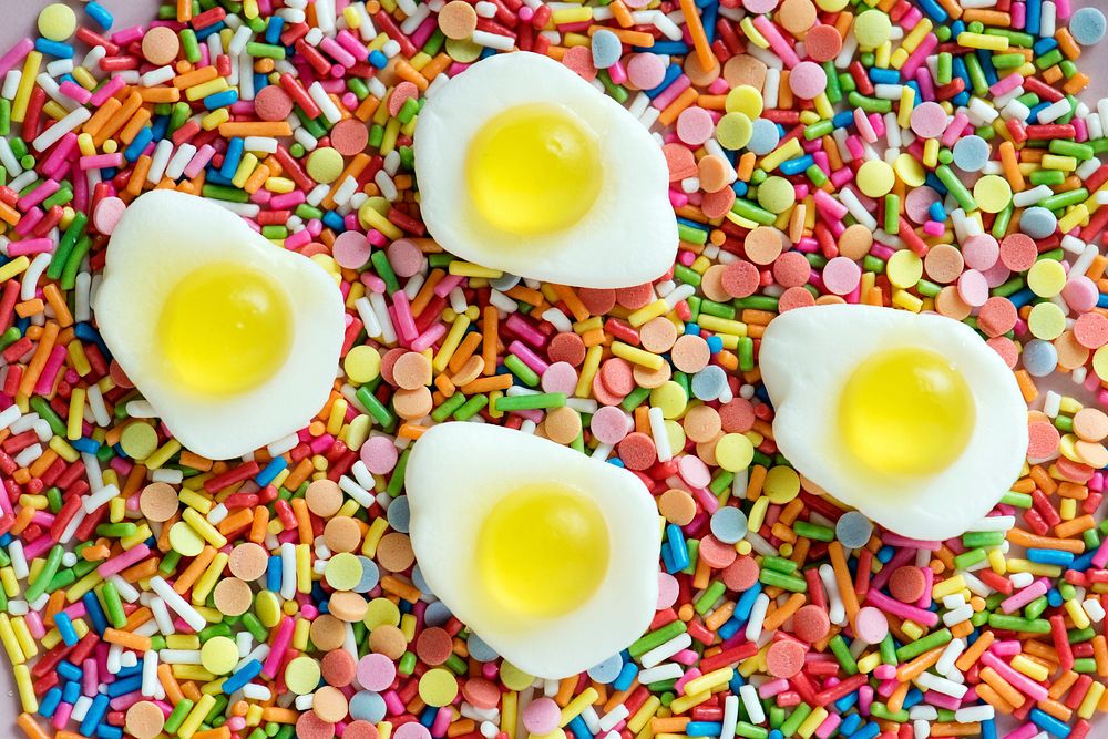 Flatlay of jelly fried eggs and sprinkles textured background