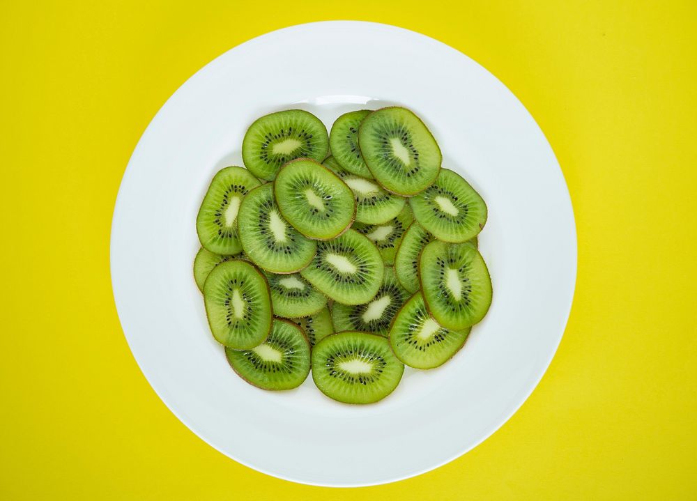 Close up of a plate of green kiwi fruit slices
