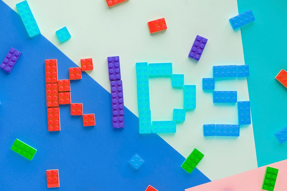 Kids spelled word with plastic blocks background