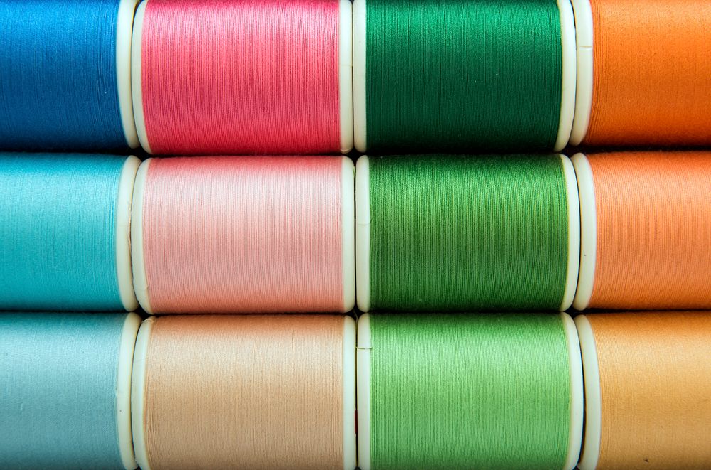 Colorful sewing threads background closeup