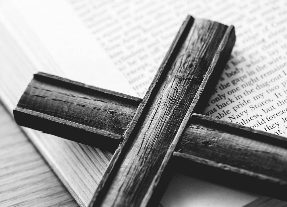 Closeup of wooden cross on bible book religion and belief concept