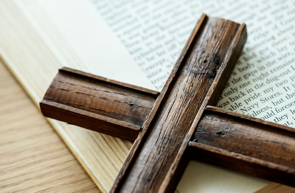 Closeup of wooden cross on bible book