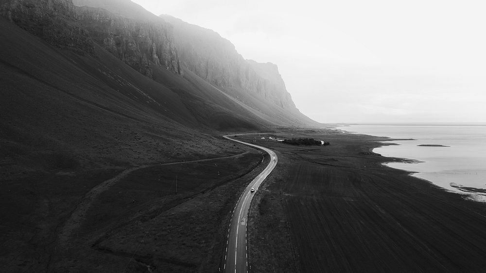 SUV car driving in the countryside drone shot grayscale