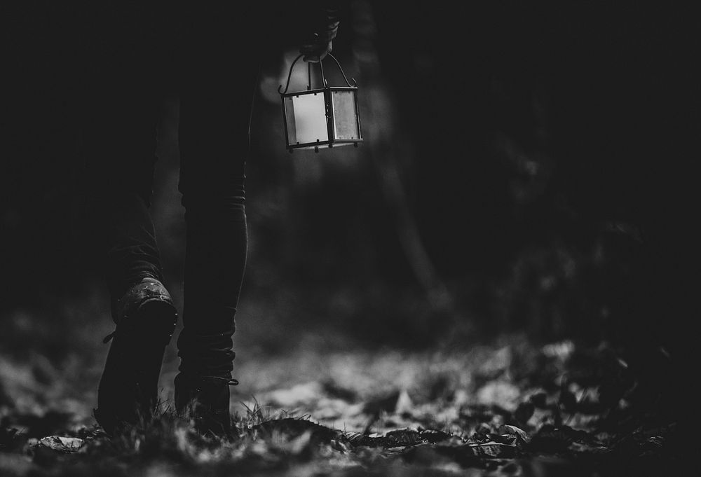 Man walking with a lantern in a woods