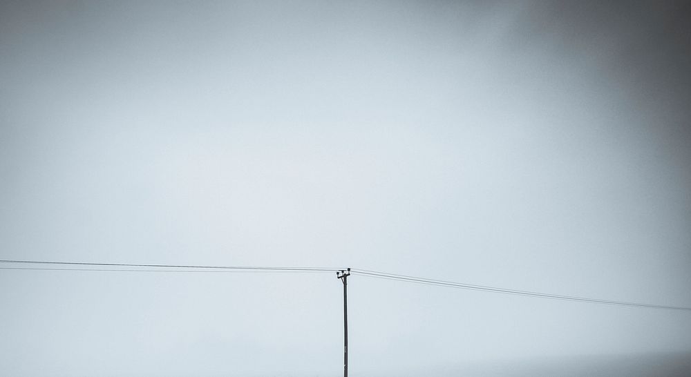 Electric pole against a misty sky