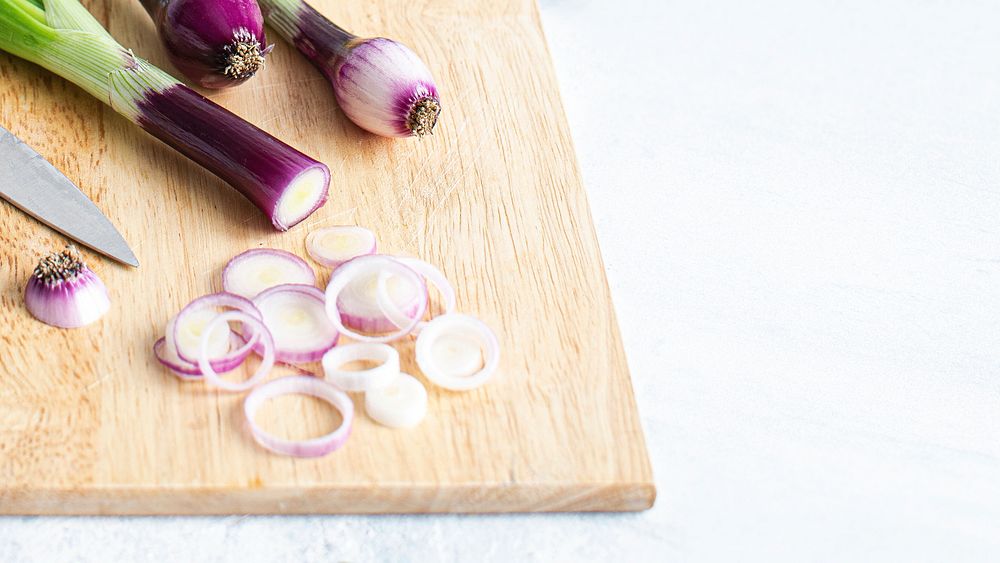 Red spring onions on a wooden cutting board
