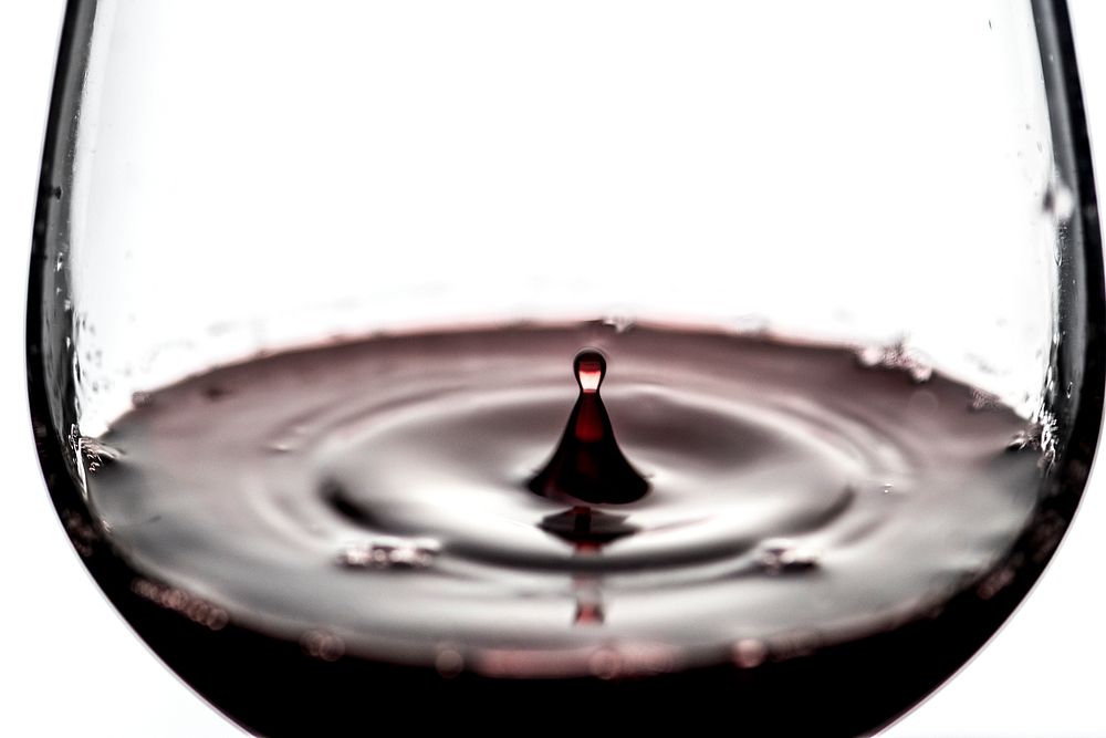 Wine drop in a glass of red wine