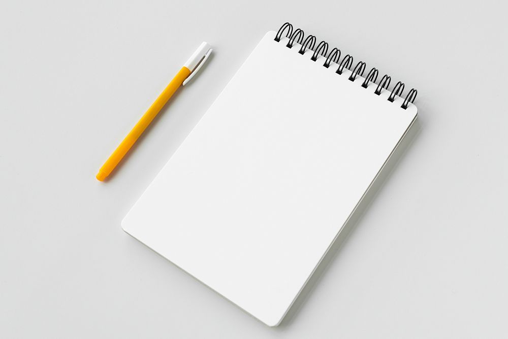 Blank plain white notebook with a yellow pen
