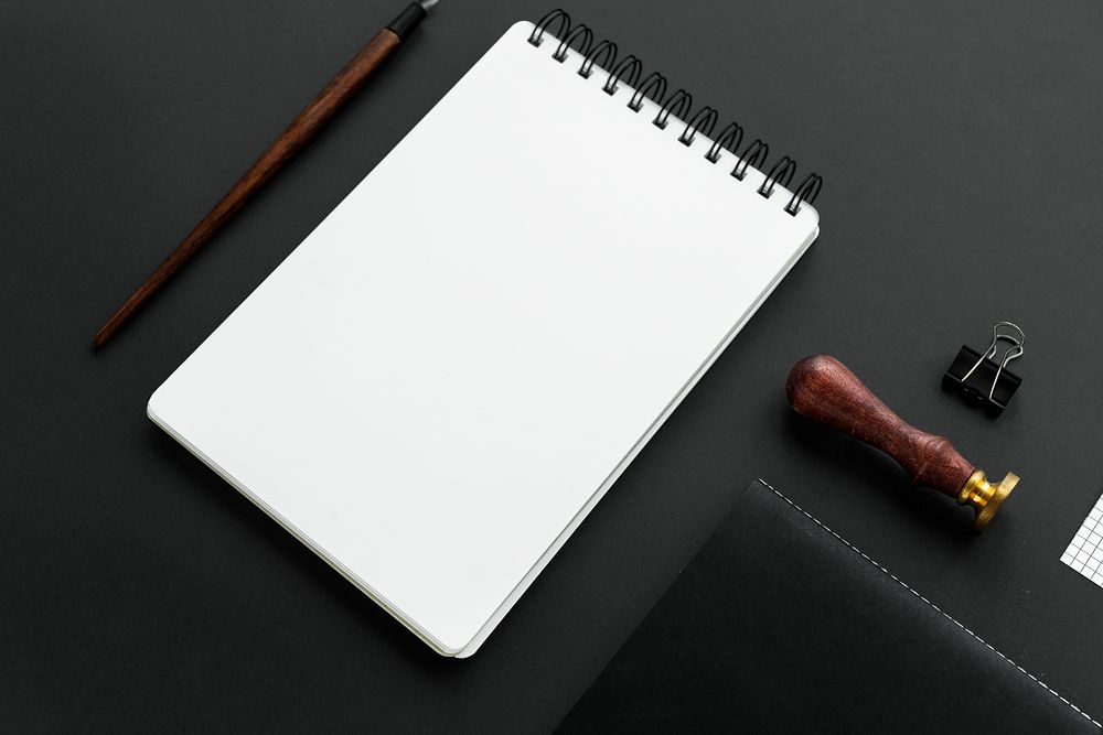 Blank white notebook on black background