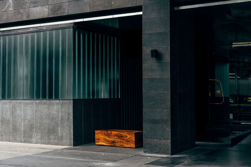 Wooden bench under a black office building