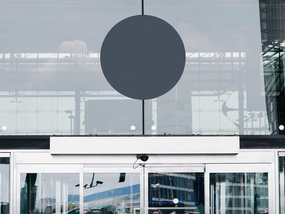 Gray circular signboard mockup in front of a building
