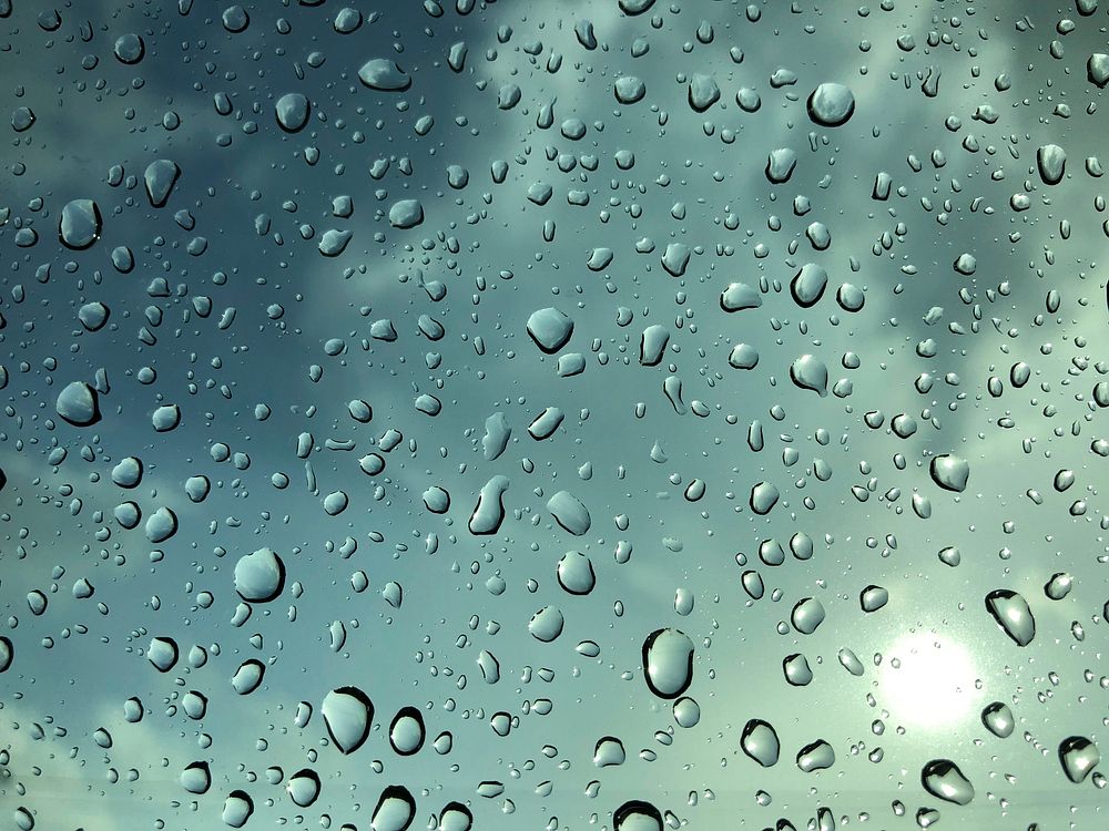 Raindrops on a window with a blue sky